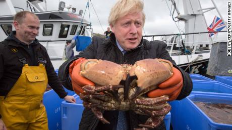 British Prime Minister Boris Johnson holds a crab at Stromness Harbour, Orkney.