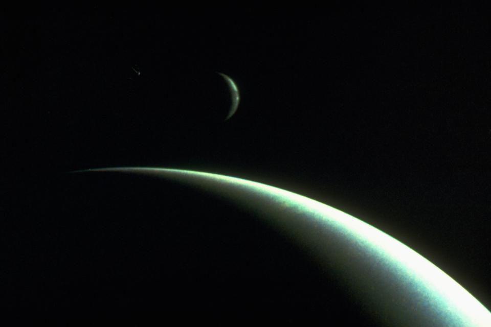 The planet Neptune and its largest moon Triton, as photographed by Voyager 2.