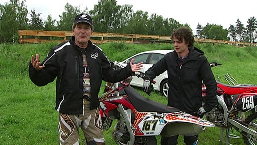 Ludwig Evertz and Max Berndt are standing next to a motocross machine