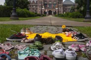Kinderschuhe liegen auf dem Boden in Sichtweite des Regierungsgebäudes im kanadischen Bundesstaat Ontario. Sie sollen an die toten indigenen Kinder erinnern, deren Gräber auf dem Gelände einer ehemalgen