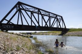 Kanada, Chestermere: Junge Leute kühlen sich in einem Bewässerungskanal ab. Die anhaltende Hitzewelle im Westen Kanadas hat für neue Höchsttemperaturen gesorgt und zu mehreren Todesfällen beigetragen. (Jeff Mcintosh/The Canadian Press/AP)