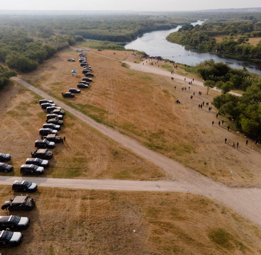 State vehicles form a line on the river border with Mexico, where many expatriates from Haiti are currently waiting.