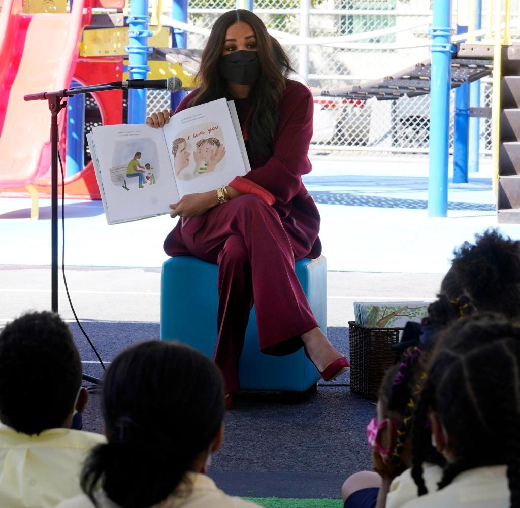 Dear kids, it's my job: Duchess Meghan (right) reads from her children's book, All Things