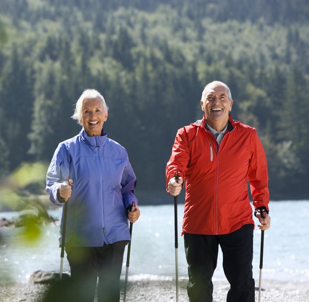 Two seniors doing Nordic walking in nature