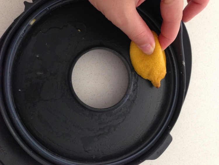 Take a lemon and clean the plastic lid of the Thermomix kitchen appliance