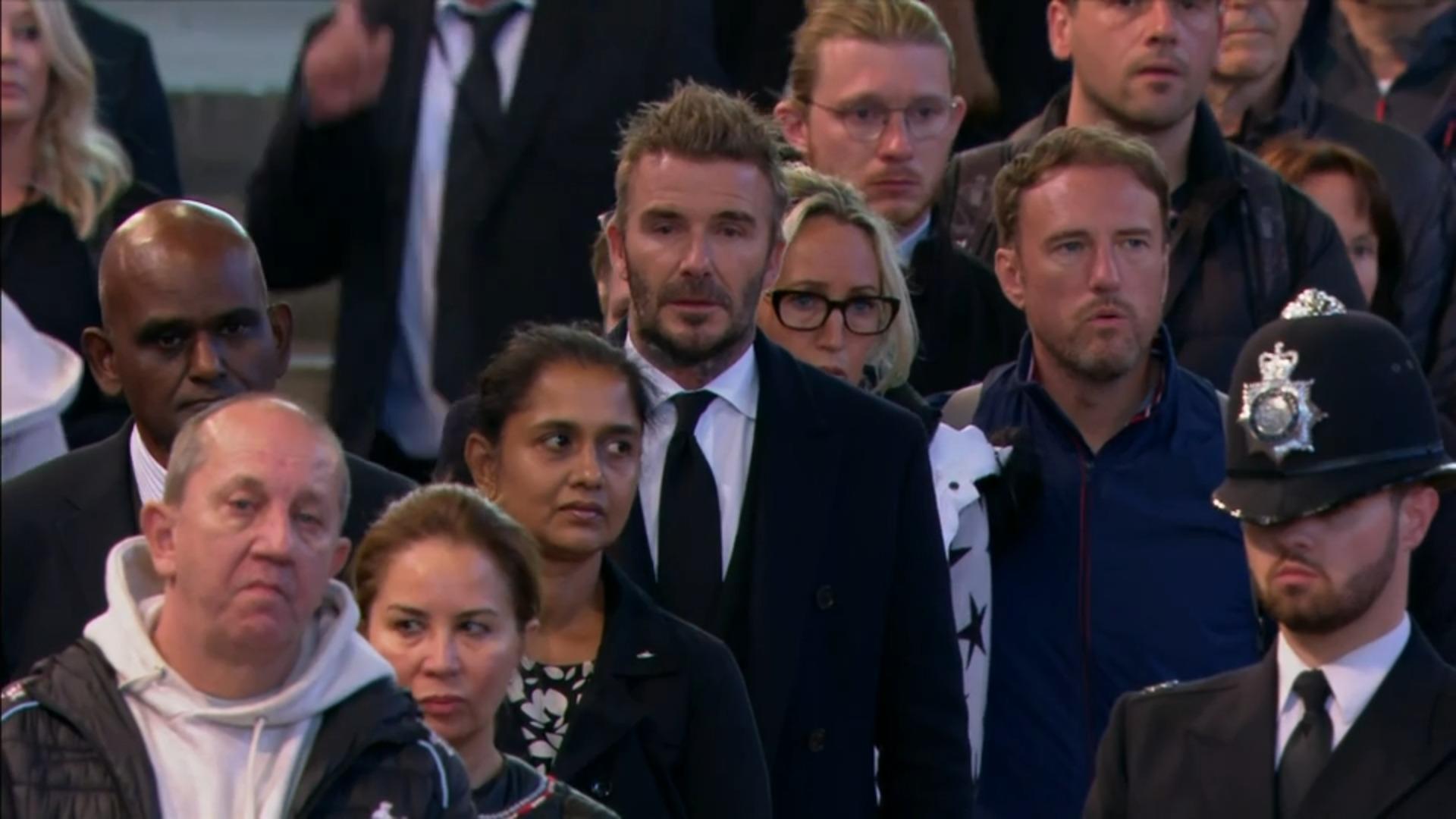 World football star David Beckham waits in front of the Queen's coffin.  he has been waiting since 2 o'clock