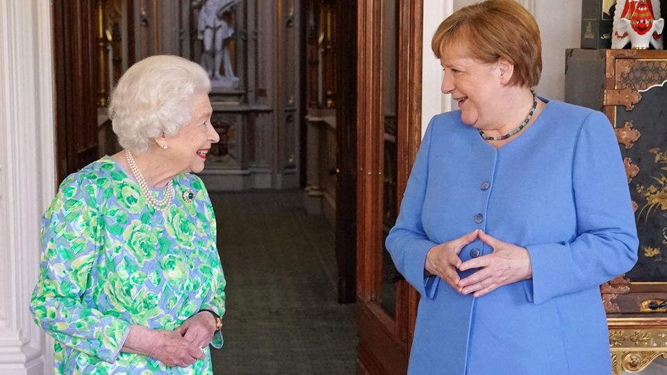 Queen Elizabeth II and Angela Merkel smile at each other