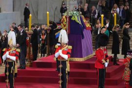 Eight queen's grandchildren stand attentively in the coffin